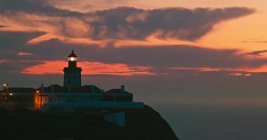 Sintra 'daki Cabo da Roca Deniz Feneri' nin silueti, günbatımının 4k görüntüsü.