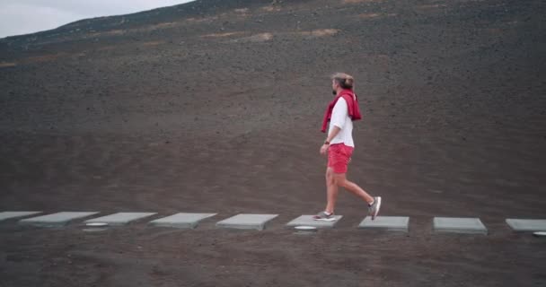 Capelinhos, Faial Island, Πορτογαλία. Καυκάσιος ξανθός άντρας περπατά σε χώμα λάβας — Αρχείο Βίντεο