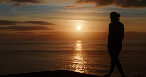 Mužská silueta s krásným západem slunce v pozadí — Stock video