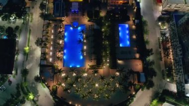 Çatıdaki havuzda tepeden aşağı sinema manzarası. Miami şehir merkezi gece sahnesi, 4K numaralı hava aracı.