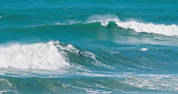 Nazare，葡萄牙。October 2020.冲浪者在大西洋上乘着泡沫般的巨浪 — 图库视频影像