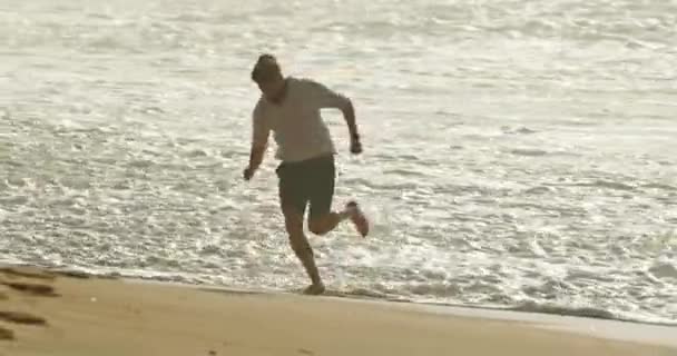Όμορφος άνθρωπος τρέχει της παραλίας Nazare στο ηλιοβασίλεμα, Πορτογαλία, Ευρώπη — Αρχείο Βίντεο