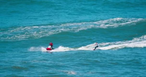 Surfer rijden na waterscooter bij Nazare kust, Portugal, Europa — Stockvideo