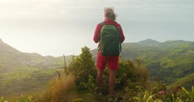 Tepede dikilirken kırmızı eşofmanlı bir sırt çantasının arka planı