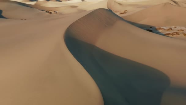 Кинематографический вид высоких песчаных дюн в лучах заката, глубокие тени от песчаных пиков — стоковое видео