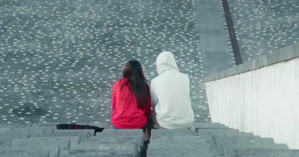 Мужчина и женщина сидят на стадионе под открытым небом — стоковое видео