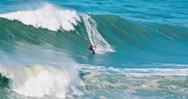 Surfer riding big wave at Nazare beach. Sportsman surfing in atlantic ocean — Stok Video