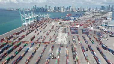 Liman iskelesinin üstündeki zaman atlaması, Miami şehir merkezindeki kargo limanının panoramasını gösteriyor.