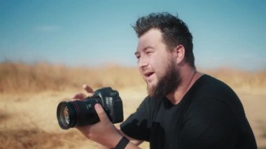 Yavaş çekim odaklı yakışıklı adam profesyonel kamera penceresine bakıyor ve ekranda