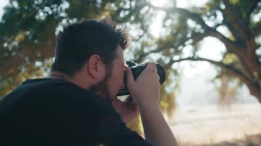 Günbatımında doğa parkında fotoğraf çeken profesyonel fotoğrafçının arka planı