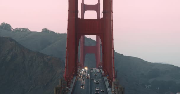 Slow motion traffic on world famous Golden Gate Bridge in pink sunset light. 4K — Stock Video