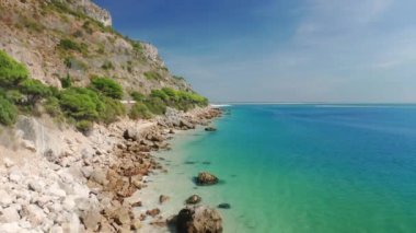 Aerial footage of a rocky cliff falling steeply into the sea
