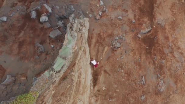 Man climbing rocky mountain at Capelinhos Volcano, Faial Island, Azores — Vídeo de Stock
