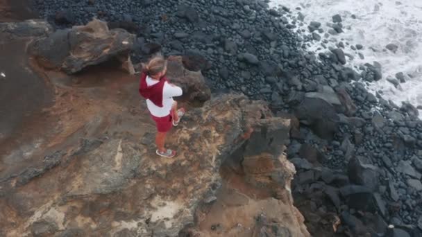 Male tourist standing on volcanic rock of Capelinhos Volcano, Faial Island — Stockvideo
