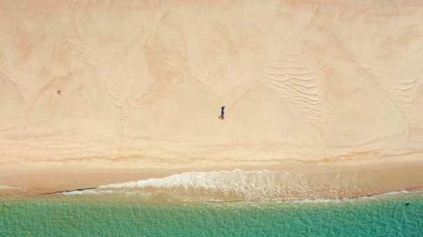 Εναέρια άποψη ενός άνδρα που τρέχει σε παρθένα όμορφη παραλία — Αρχείο Βίντεο
