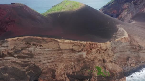 Человек, идущий по скале у вулкана Капелиньюс, остров Фаял, Азорские острова, Португалия — стоковое видео