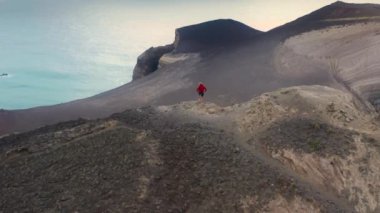 Capelinhos Yanardağı 'nın tepesinde duran sporcu, Faial Adası, Azores, Portekiz