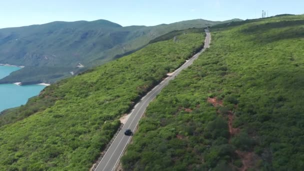 Horní pohled na silnici táhnoucí se přes strmé kopce pokryté bujnou vegetací — Stock video