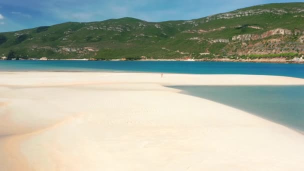 Un turista corriendo a lo largo de la playa de arena junto al mar tranquilo — Vídeo de stock