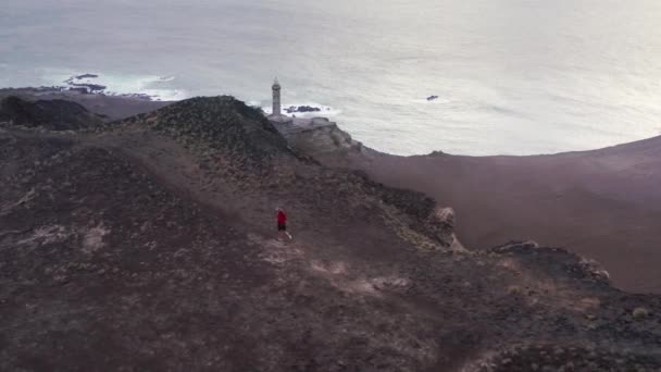 Tipo corriendo en el camino con el Centro de Interpretación de Volcán de Capelinhos — Vídeo de stock