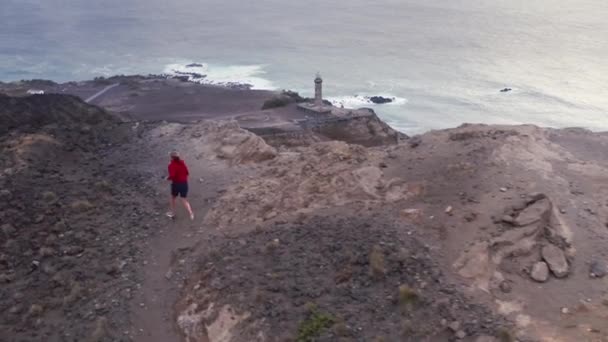 Jogger correndo na estrada para o farol da Ponta dos Capelinhos, Ilha do Faial — Vídeo de Stock