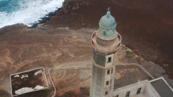 Vista aérea del faro desaparecido rodeado por el océano azul — Vídeos de Stock