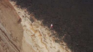 Aerial footage of a tourist exploring the island, washed by bluish waters