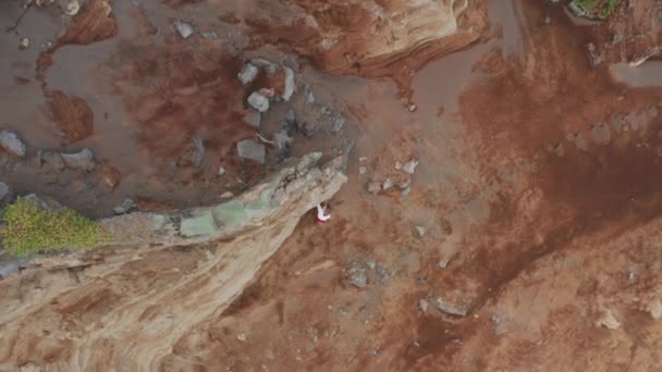 Vista aérea de um homem subindo na rocha dentro da paisagem vulcânica única — Vídeo de Stock