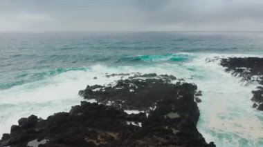Köpüklü okyanus dalgalarıyla yıkanmış muhteşem sahilin insansız hava aracı görüntüleri.