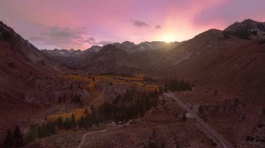 Cinematic view of scenic pink sunset sky above the high summit snowy peaks