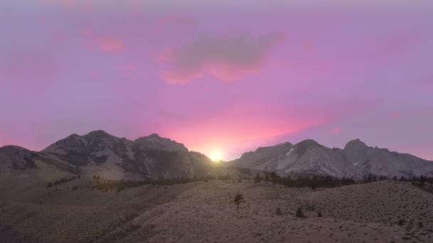 Beautiful pink and purple sky at sunset. Mountains aerial. Peaks covered by snow — Video Stock