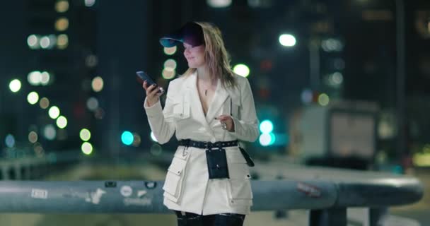 Stylová žena poslouchá hudbu, tančí a dívá se na displej svého smartphonu 4K — Stock video
