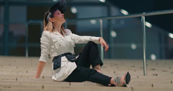 Stylový model odpočinku na schodech. Hezká žena těší noční scény v centru — Stock video