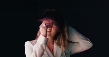 Beyaz ceketli kadın yüzünü modern COVID 19 yüz kalkanı 4K ile kapatıyor.