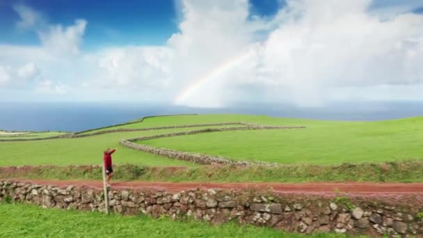 Mann läuft auf Straße in Feldern der Insel Sao Jorge, Azoren, Portugal, Europa — Stockvideo