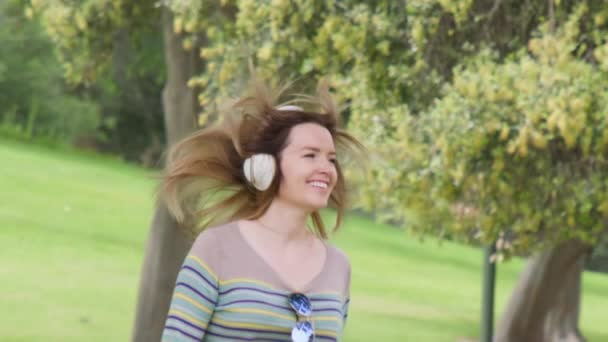スローモーション幸せな若い女性で無線ヘッドフォンダンスと楽しみを持っています4K — ストック動画