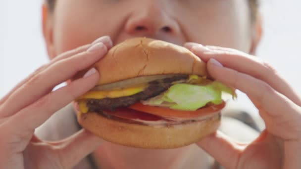 Smiling caucasian woman eating burger enjoying delicious juicy hamburger, RED 8K — Αρχείο Βίντεο
