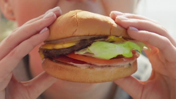 Happy smiling woman eating delicious juicy delicious cheeseburger, RED footage — Stock videók