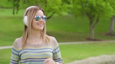 Portrait of young caucasian blonde woman with headphones listening to music, RED