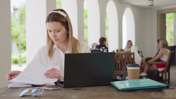 Fokuserad kvinnlig kontorschef arbetar med dokument utanför, RED Helium 8K — Stockvideo