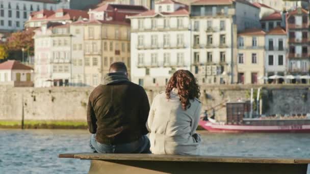 Porto, Portugal. Touristen ruhen sich an einem Fluss aus, hinter dem gekachelte Gebäude stehen — Stockvideo