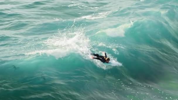 Surfista andando e girando com spray na onda azul do oceano, surfando o estilo de vida do oceano — Vídeo de Stock