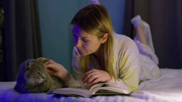 Ontspannen Kaukasische vrouw genieten avond tijd met haar tabby grijs kat thuis 8K — Stockvideo