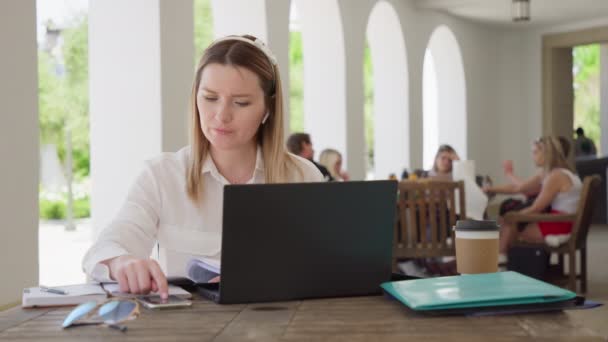 Zakelijke vrouw met rekenmachine en laptop telt inkomens, uitgaven of belastingen, rood — Stockvideo