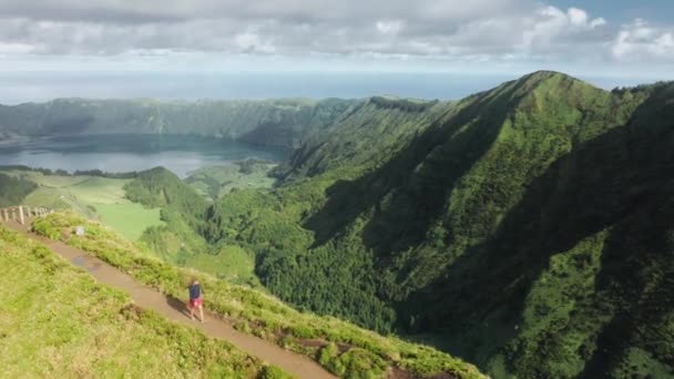 Turista disfruta de una hermosa escena en un mirador en una colina — Vídeo de stock