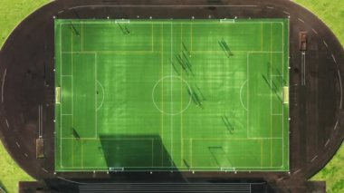 Kenarında bir futbol sahası olan kayalık bir uçurum manzarası