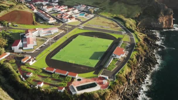 Małe, urocze miasteczko z boiskiem do piłki nożnej na wzgórzu — Wideo stockowe