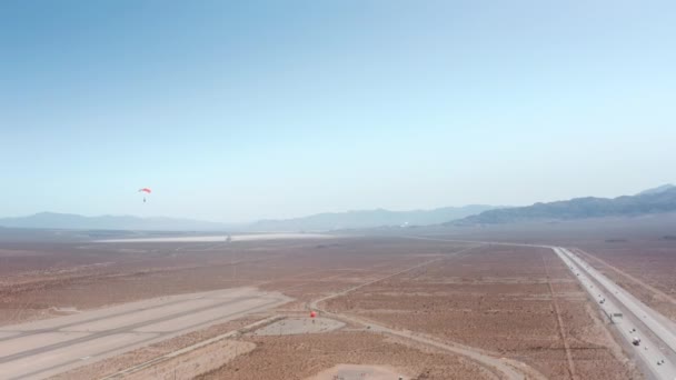 Paraquedas esportivos descem ao aeródromo do deserto. Paraquedistas fazendo figura extrema — Vídeo de Stock