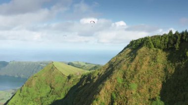 Yeşil dağların üzerinden uçan paragliderler, Miradouro do Cerrado das Freiras