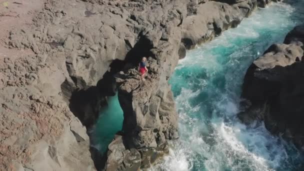 사람은 위에서 볼 수있는 바와 같이 용암 과 화석 절벽을 따라 걸어 다닌다 — 비디오